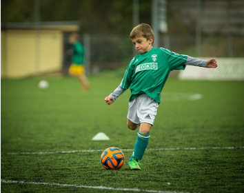 boy in green jersey playing soccer